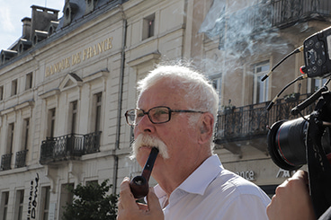 Jean Mermet fume la pipe devant la boutique La Pipe Rit